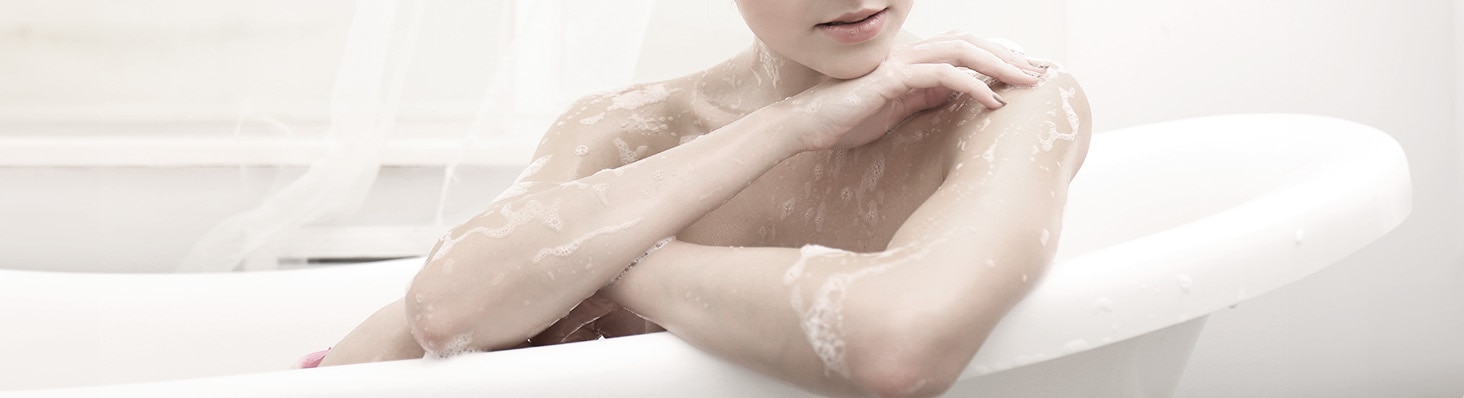 Mujer con piel seca tomando un baño en una tina