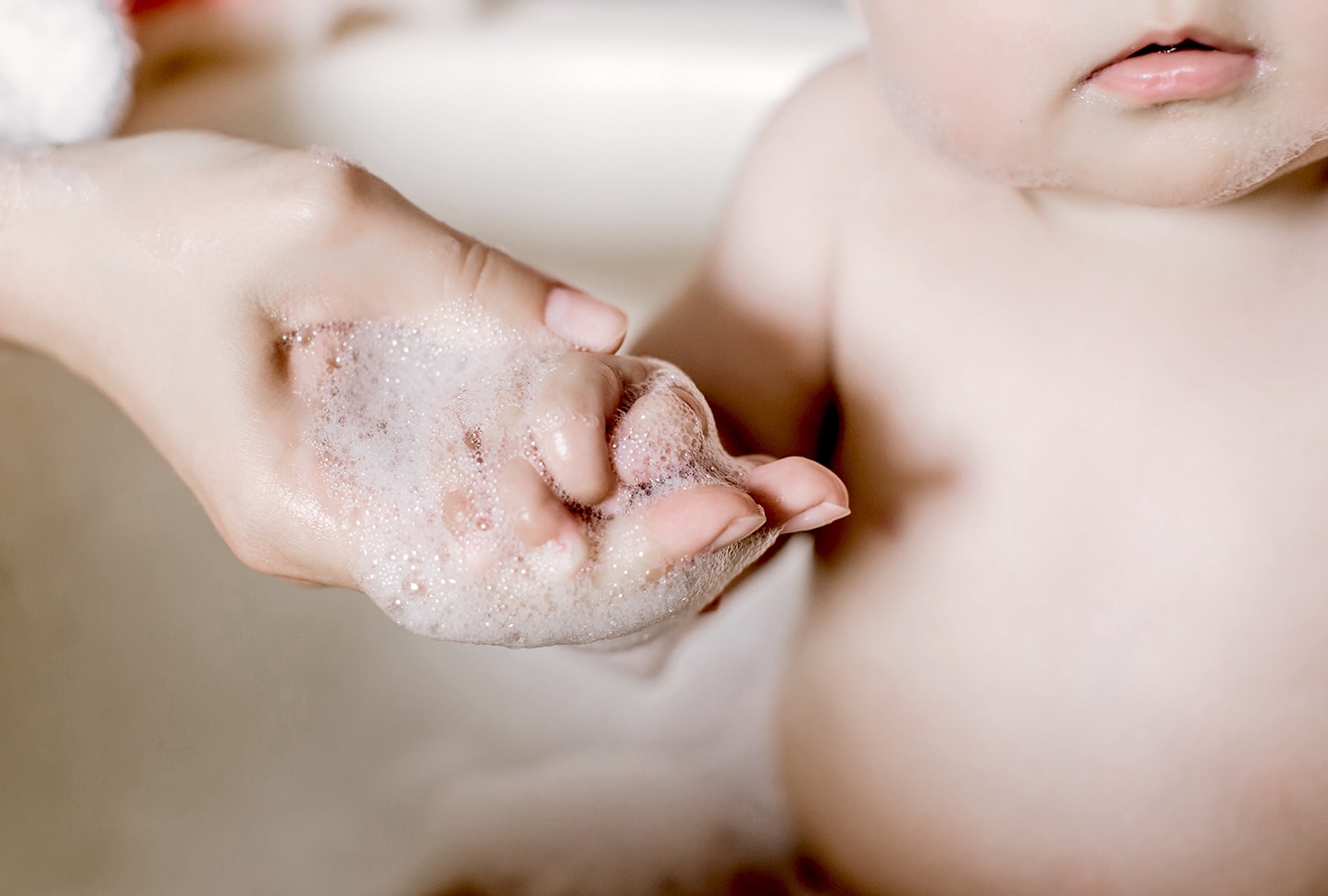 Mujer lavando suavemente las manos del bebe
